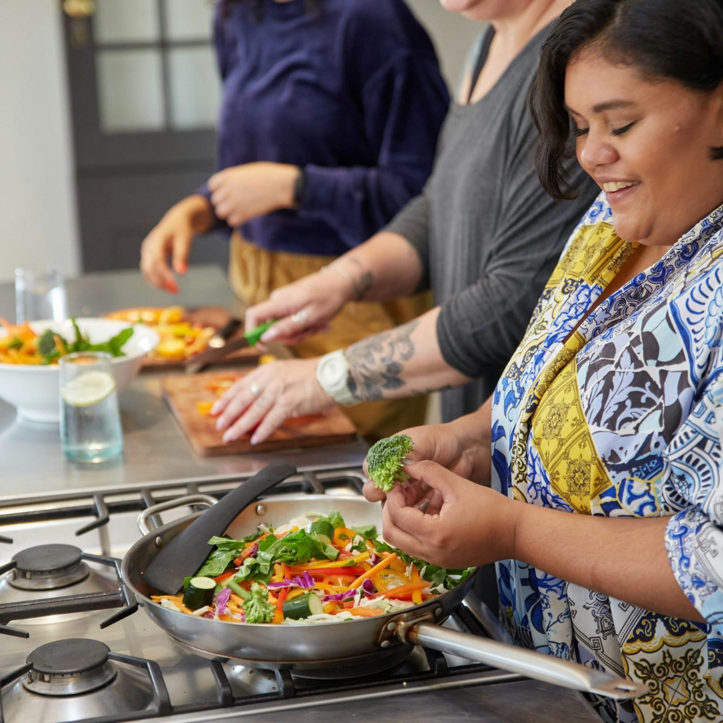 Community members collaborating in a contemporary kitchen, exchanging recipes and techniques